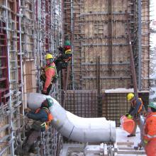 NAC employees preparing wall formwork surrounding large pipe penetration