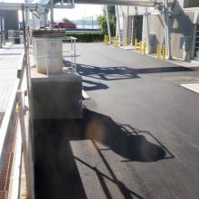 Roadway and grated walkway next to process piping outdoors