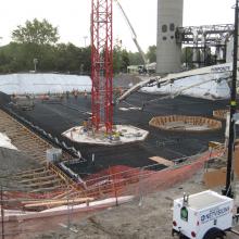 Large concrete pour by pump truck featuring base of tower crane