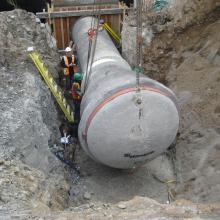 Large concrete pipe being installed into building foundation